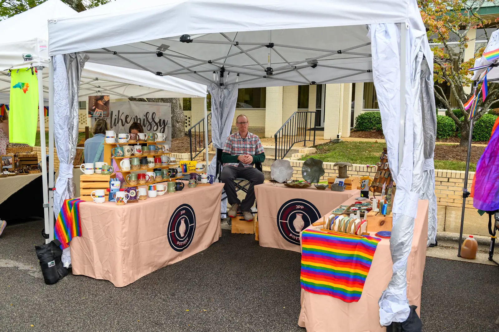 A potter sells handmade mugs and dishes from a booth at a street festival in downtown Wake Forest.