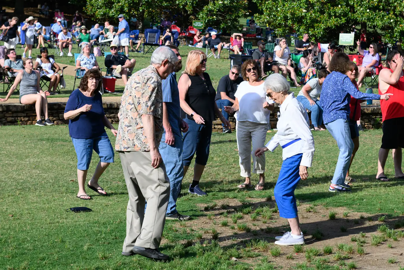 Concertgoers dance on the lawn at E. Carroll Joyner Park in Wake Forest, where the town lights the gardens for its Evening Holiday Walk each December.