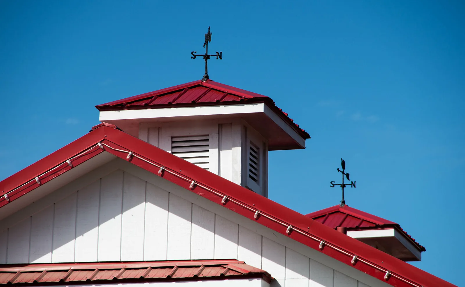 Weathervanes top a red-roofed barn at Hill Ridge Farms in Youngsville, home of a fall pumpkin festival north of Wake Forest.