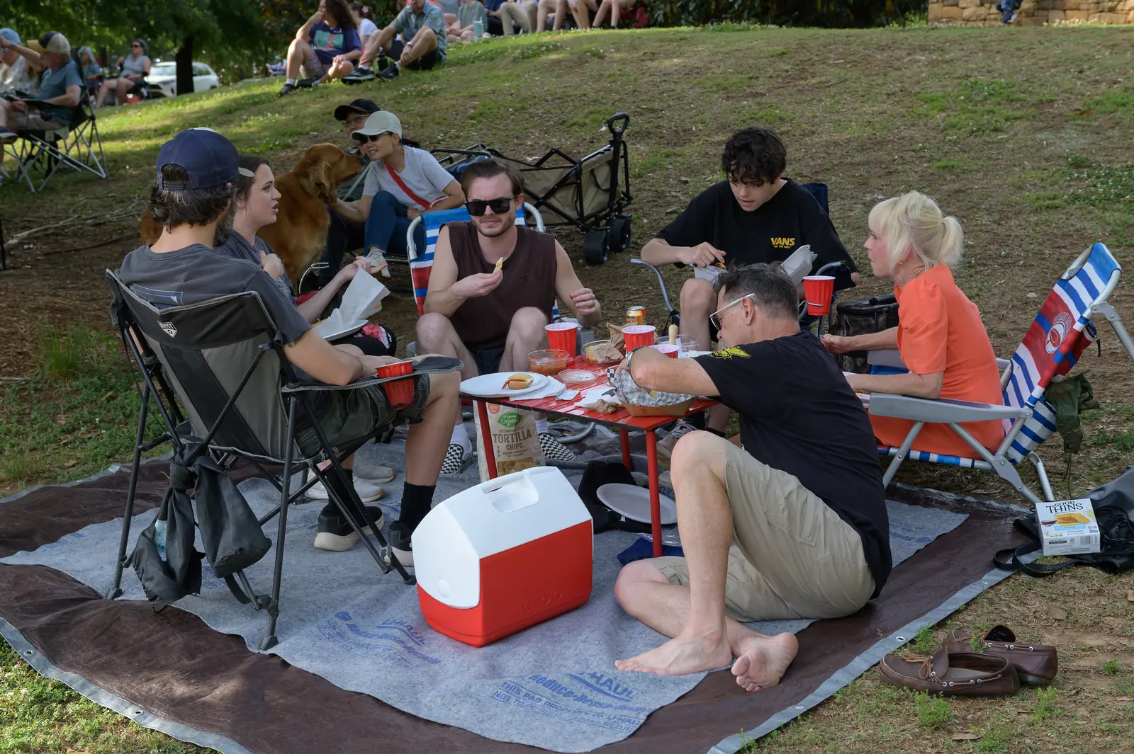 Friends share a picnic on the lawn at E. Carroll Joyner Park in Wake Forest during a free Six Sundays in Spring concert.