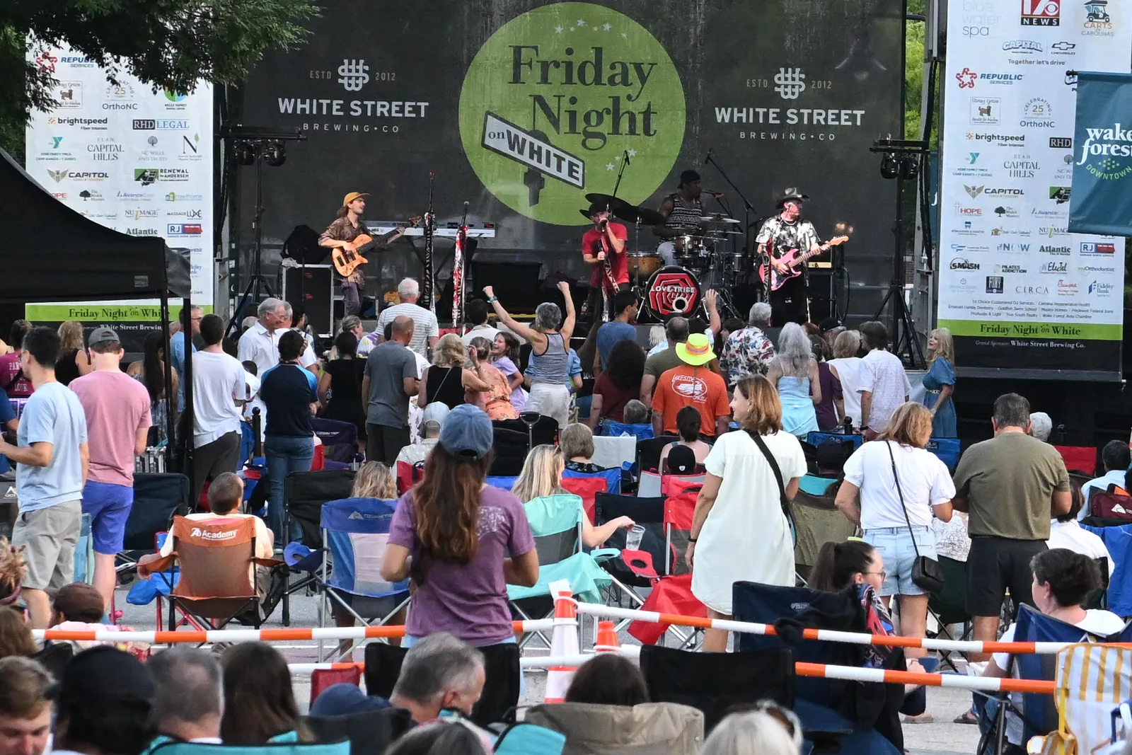 A crowd with lawn chairs fills South White Street in front of the Friday Night on White stage in downtown Wake Forest.