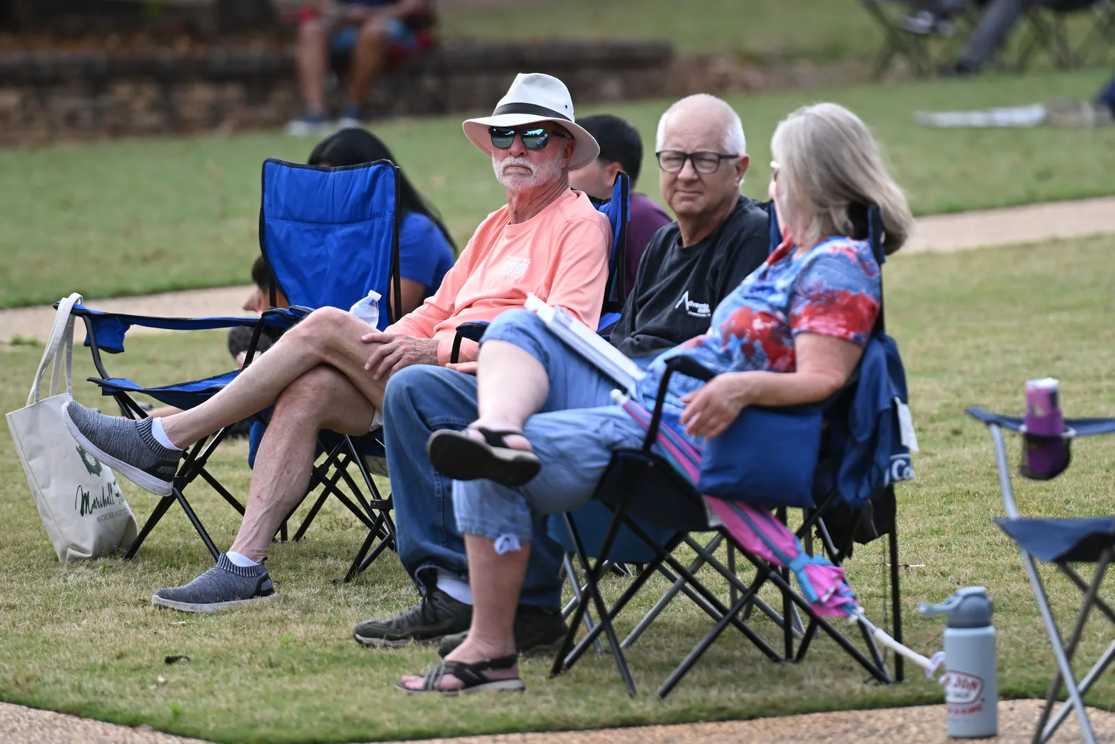 Concertgoers relax on the lawn at E. Carroll Joyner Park in Wake Forest, where the town lights the gardens for its Evening Holiday Walk each December.
