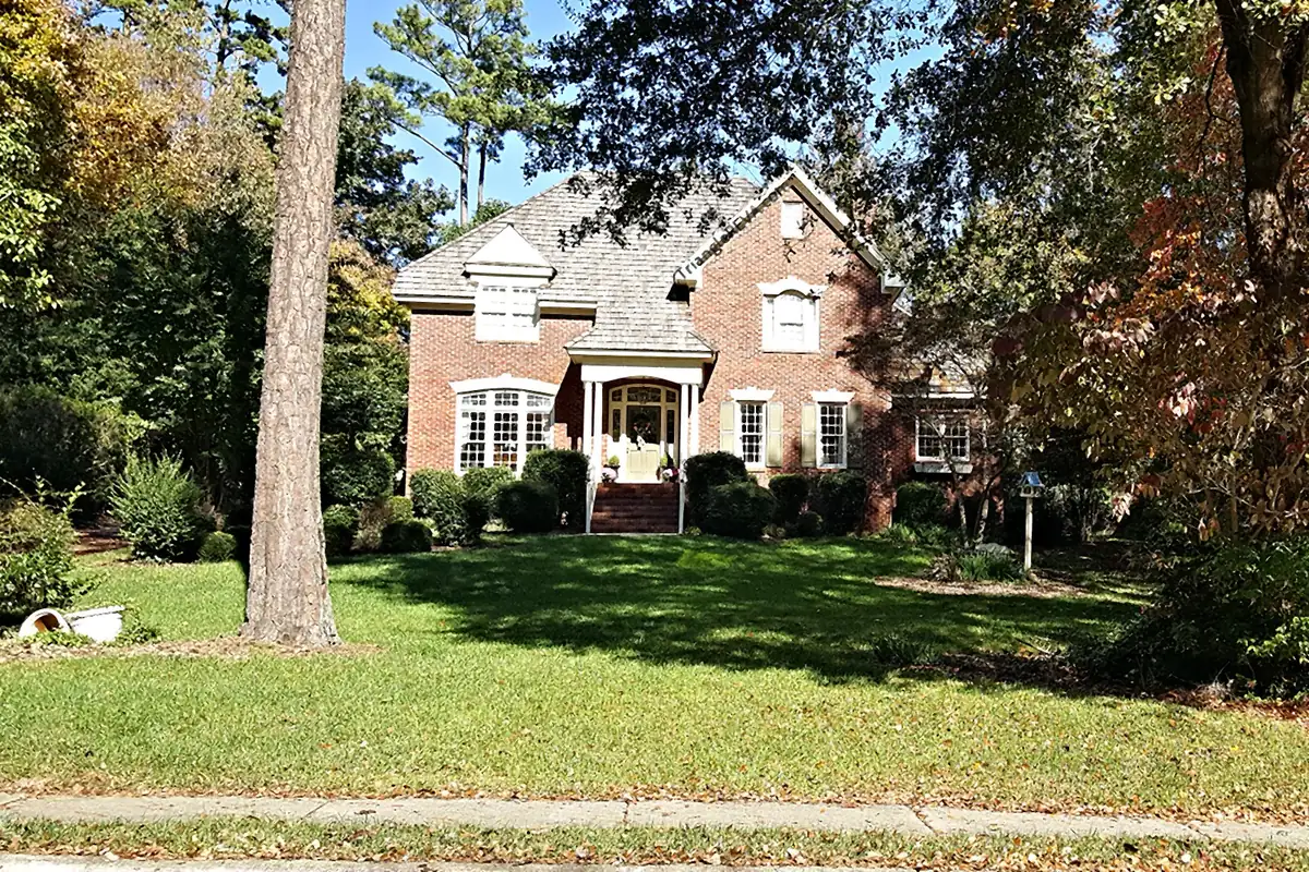 A brick home on a tree-lined lot in the Crenshaw Hall neighborhood of Wake Forest.