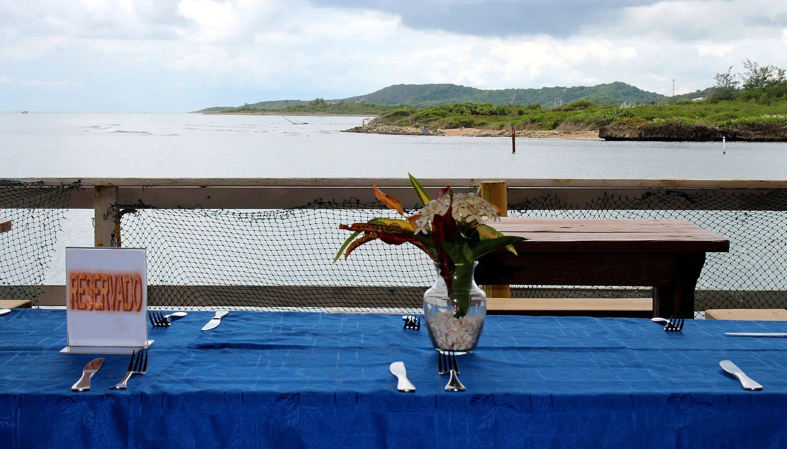 A table set for dinner on an open-air restaurant deck by the water in Honduras. The photo was not taken in Wake Forest.
