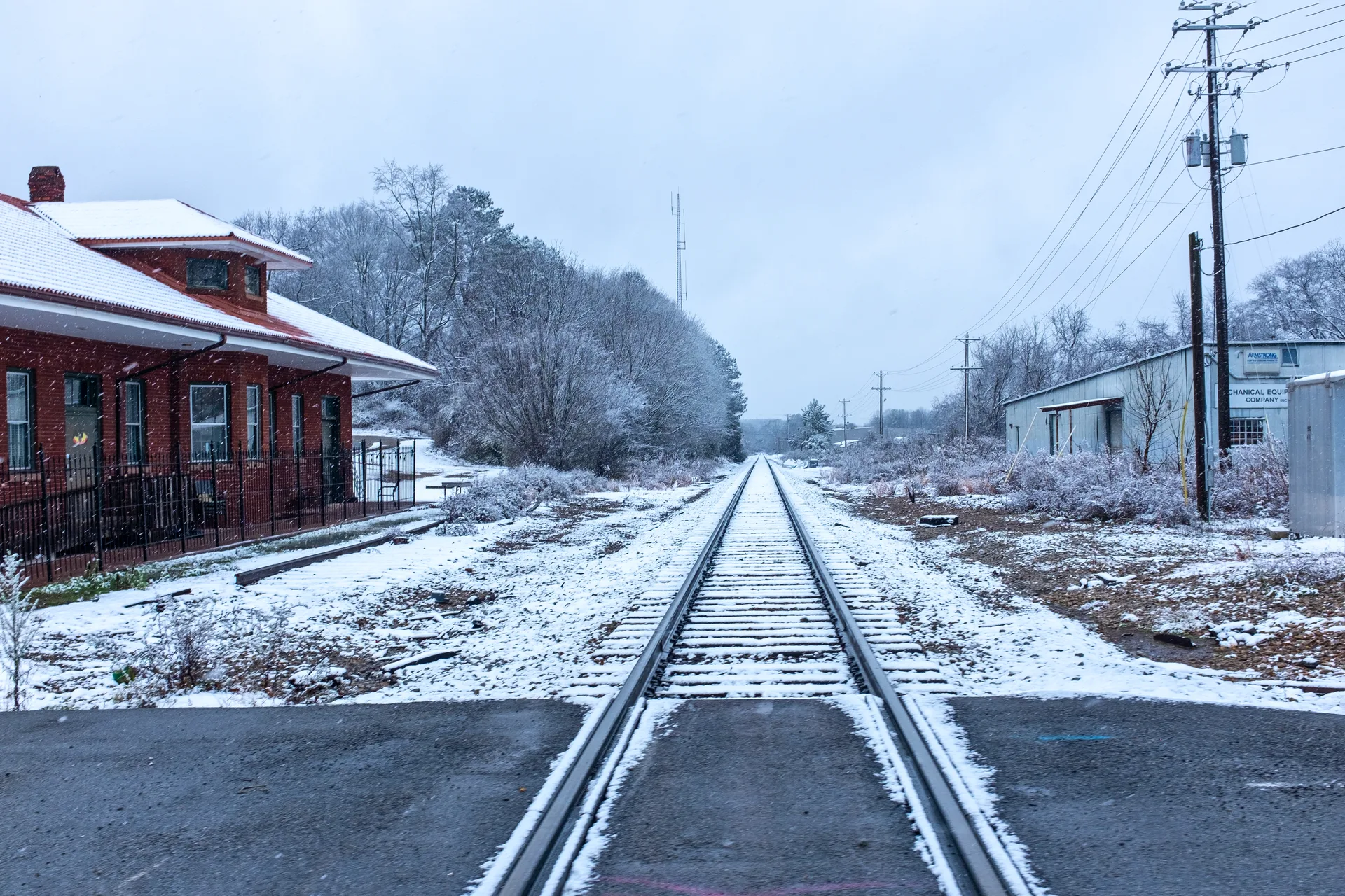 A street crosses a CSX track at grade beside the old depot in Lawrenceville, Georgia. The picture does not show Rogers Road.