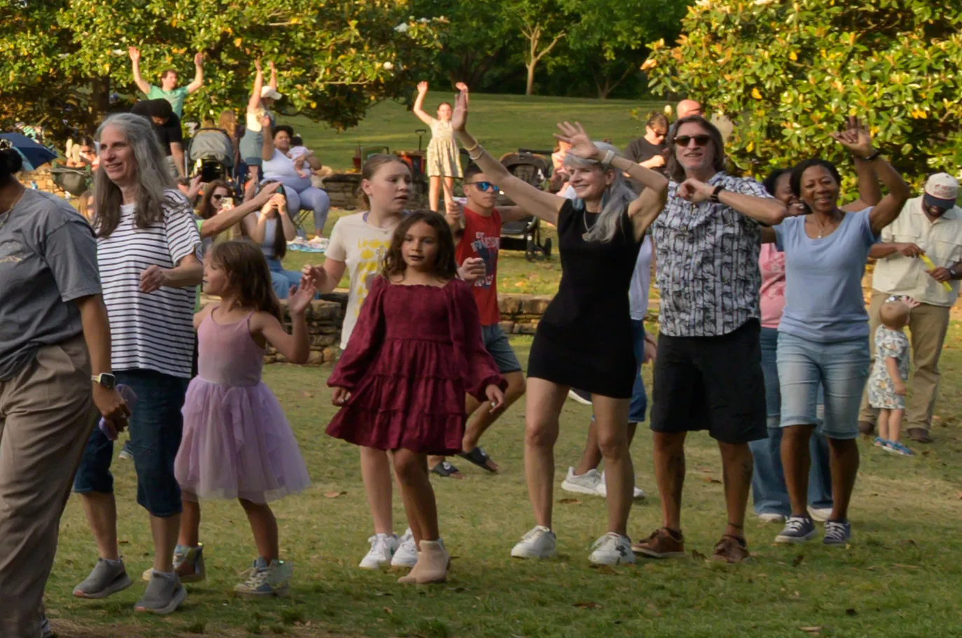 Children and parents dance on the lawn at E. Carroll Joyner Park in Wake Forest during a free evening concert.