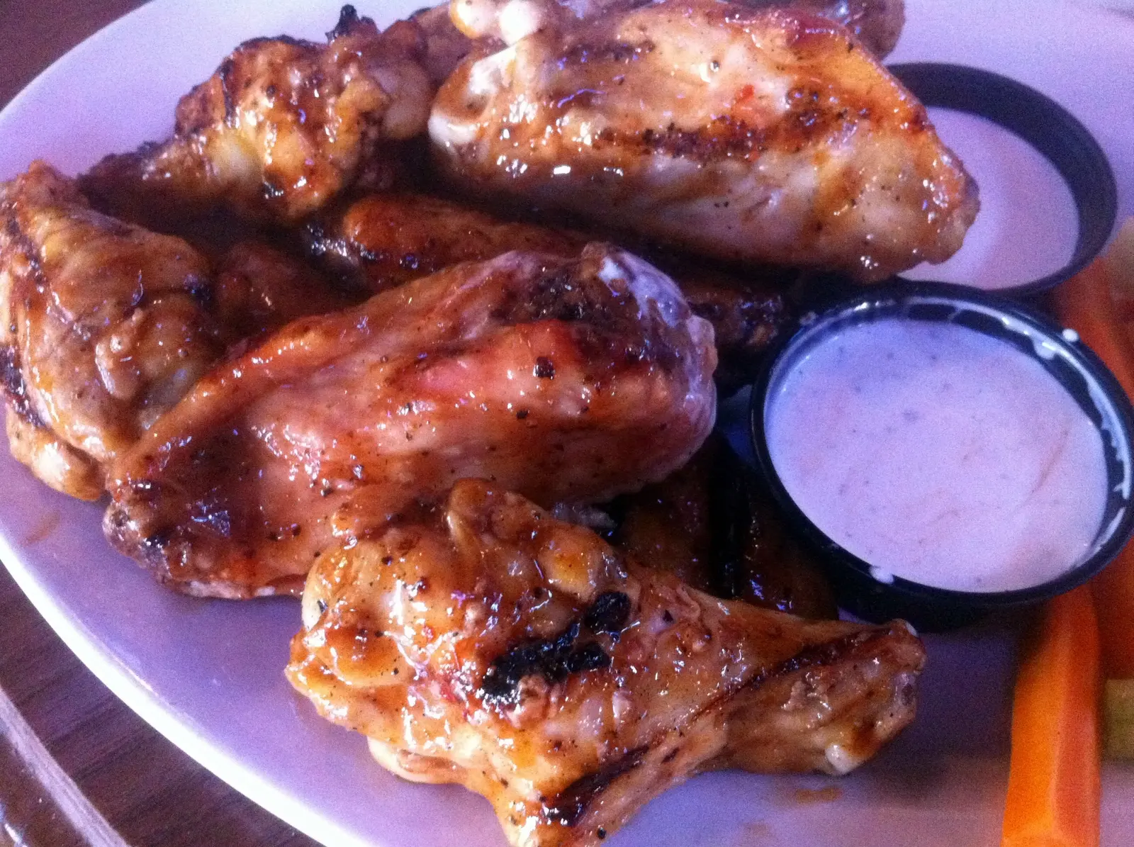 A plate of grilled chicken wings with ranch dressing and carrot sticks at a restaurant in Charlotte, N.C. The photo was not taken in Wake Forest.